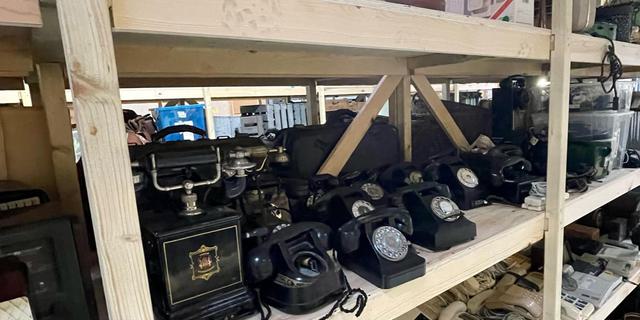 An assortment of vintage telephones, from Victorian candlestick-style to black and cream Bakelite rotary designs