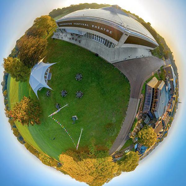 A 360 degree image of the CFT site taken from the air. The grass of Oaklands Park and the theatre buildings look like they are on a globe, stretching round, with the blue sky surrounding them.