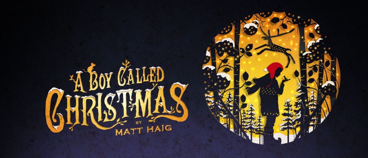 A circular cut-out silhouette, like an old-fashioned fairy story image, shows a boy wearing a red cap, a scarf, coat and boots, holding up his hand on which is perched a mouse. He stands surrounded by snow-laden pine trees, and a reindeer is leaping above his head. The title 'A Boy Called Christmas' is written in old-fashioned gold capital letters to the left side.