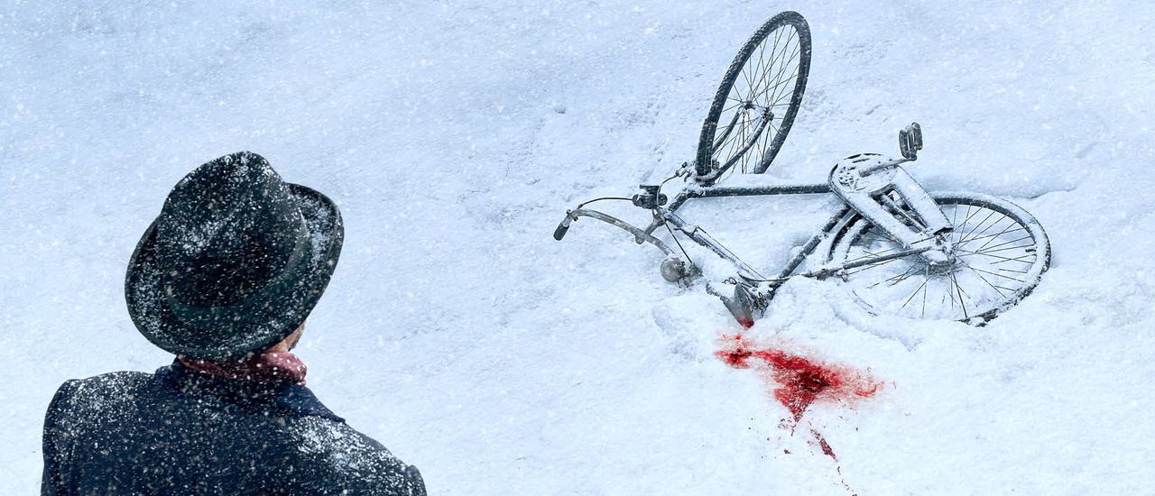 A black bicycle lies on the ground, half covered in snow. Next to the bike, a patch of snow is stained red with blood. In the foreground, a man is turned away from the camera looking towards the bike, he is wearing a black wide-brimmed hat and a black jacket, which are speckled with snow.
