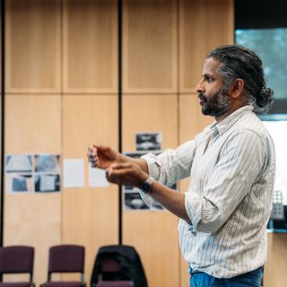 A man is gestures with his arms as he speaks.
