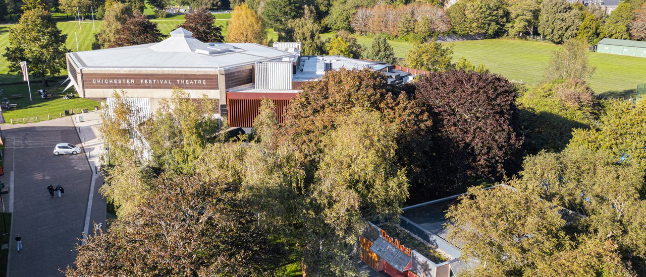 An aerial shot of Chichester Festival Theatre and The Nest, surrounded by trees and parkland.