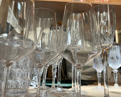 A selection of wine glasses arranged on a wooden shelf.