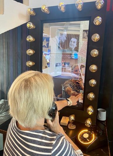 A woman with blonde hair touches an interactive screen