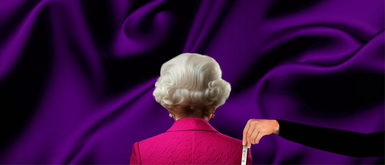 An imitation of Queen Elizabeth II from behind: an older woman with nearly styled, short, grey, wavy hair, pearl earrings and a pink blazer. The background is a rich purple silk.