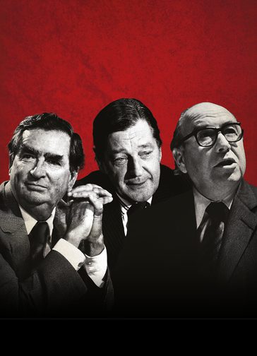 Three men in black and white in front of a red textured background. They are all wearing suits, the man on the right has glasses, is looking off to the right abd has his mouth open slightly. The man in the middle is looking down, a complacent look on his face. The man on the left has his hands clasped together in front of him and looking off to the left.