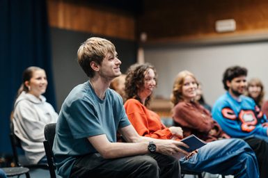 A group of young people smiling and engaging in conversation.