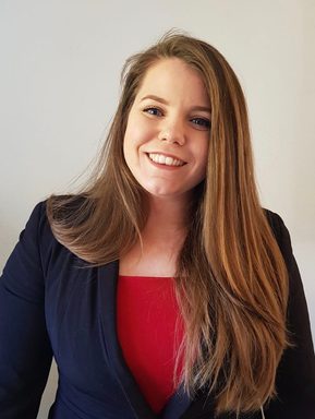A woman with medium brown hair smiles warmly.