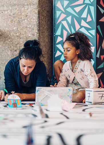 A mother and daughter sat drawing together, a look of concentration on both their.