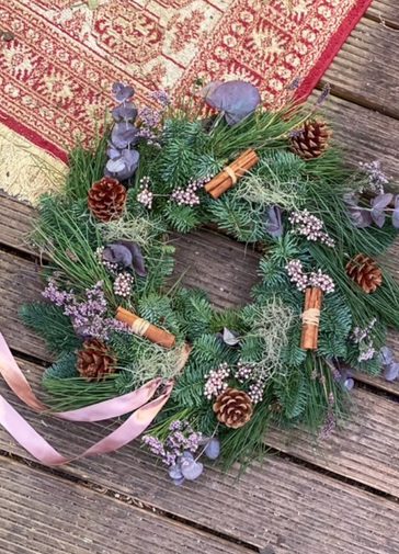 Three beautiful festive wreaths in a row. They are each decorated in a unique way, with ribbons, dried fruits and flowers.