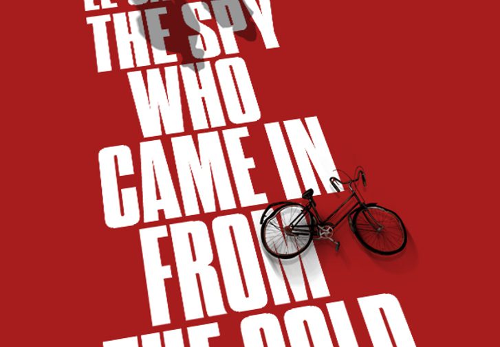 A red graphic with bold, white all-caps text that reads 'John le Carre's The Spy Who Came In From The Cold, adapted by David Eldridge, directed by Jeremy Herrin'. There is a small graphic of a couple, the man wearing a spy-style trench coat and hat, and a bike.