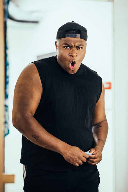 An actor stood in a backstage corridor pulling a dramtic but excited face.