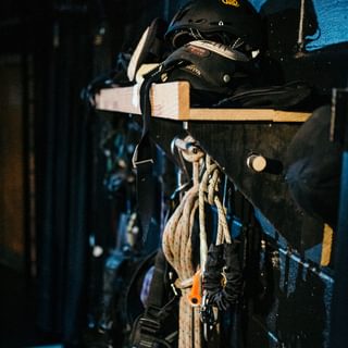 Ropes, harnesses and hard hats stored on a wall backstage
