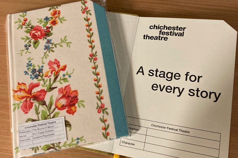 Two hardback notebooks: one is bound in floral fabric, resting on an open notebook page with the Chichester Festival Theatre logo and the words 'A stage for every story'