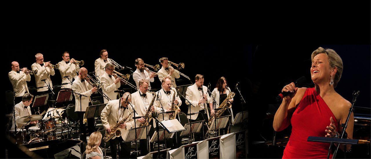 A band of musicians, all playing brass instruments and dressed in white jackets, with a blonde female singer in a red dress singing beside them.